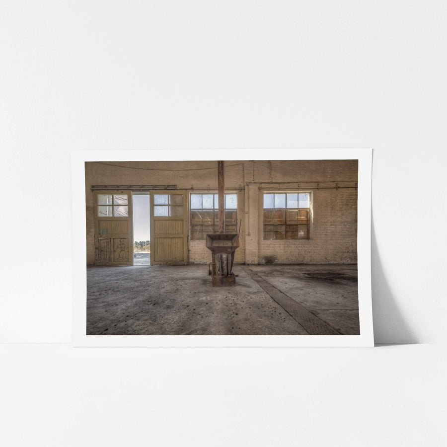 Stove Heater at Portland Cement Works, a cast-iron stove sits alone at the centre of a wide concrete floor.