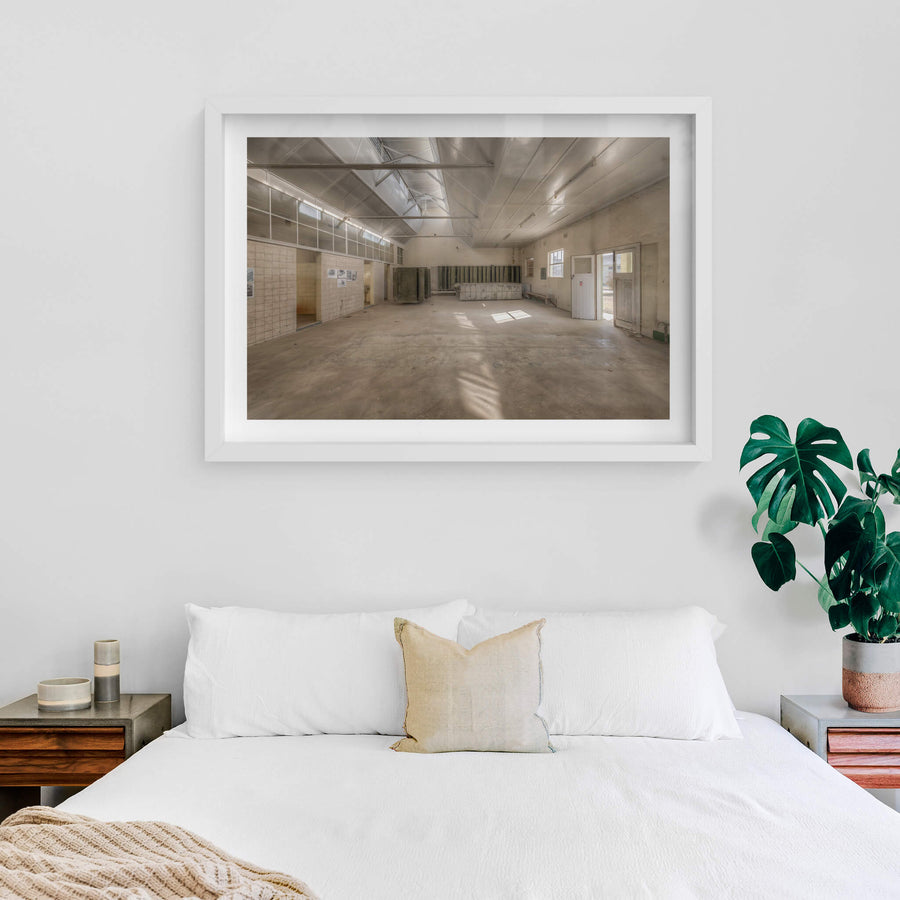 Wash House Facing West at Portland Cement Works, light falls through clerestory windows and cuts across the concrete floor.