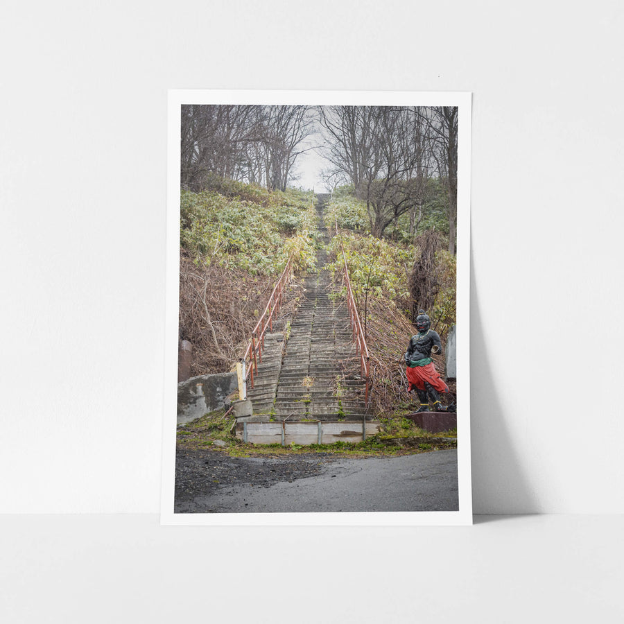 Shrine Stairway at Streetscapes of Yubari, concrete steps climb a steep hillside, narrowing as they disappear into bare.