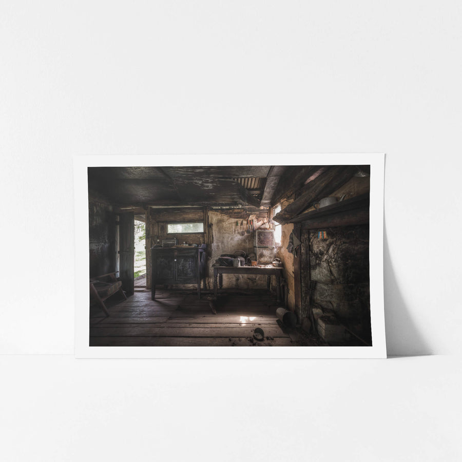 Kitchen at Woolla, a low ceiling of corrugated iron and rough-hewn beams presses down over wide timber floorboards.