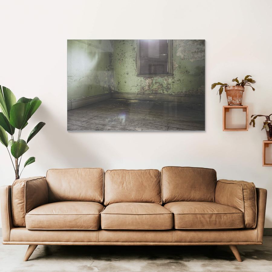 Bare Guest Room at Terminus Hotel, light seeps in through a boarded window, casting a dull glow across the floorboards.