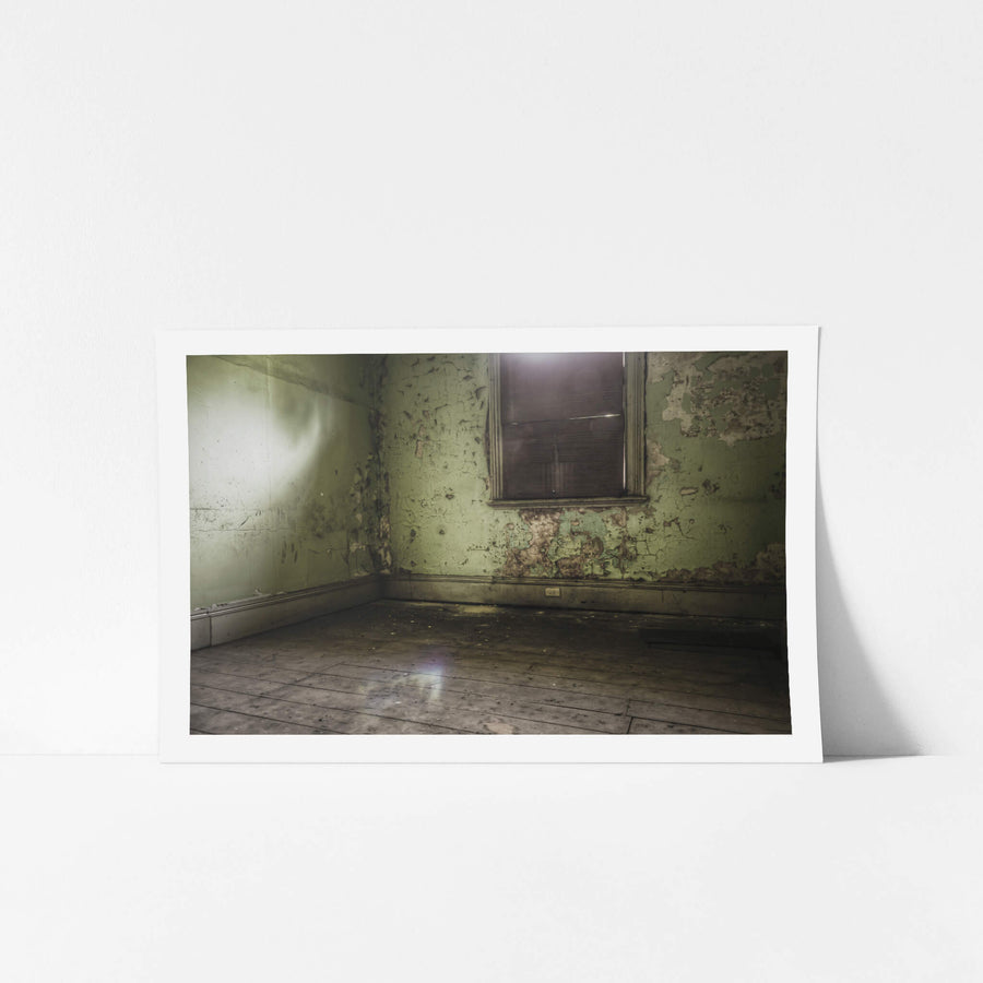 Bare Guest Room at Terminus Hotel, light seeps in through a boarded window, casting a dull glow across the floorboards.