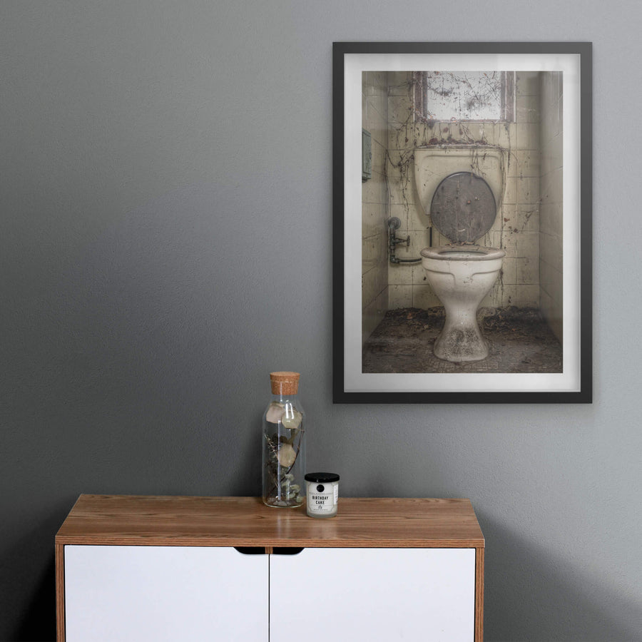 Toilet at Terminus Hotel, a white ceramic pedestal toilet sits centred in a narrow tiled cubicle.