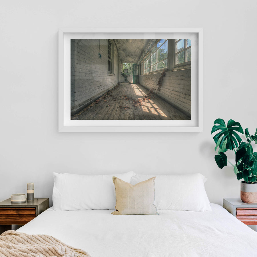 Balcony at The Asylum, a narrow enclosed verandah runs between white-painted brick walls.