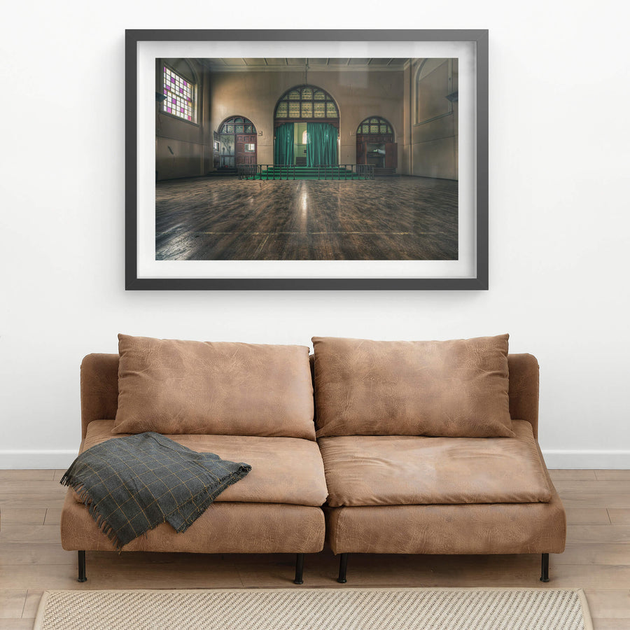 Chapel at The Asylum, a large hall with worn timber floorboards stretching toward a raised stage.