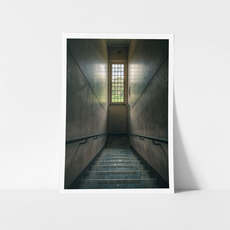 Glimmer at The Asylum, a concrete stairwell descends between narrow walls.