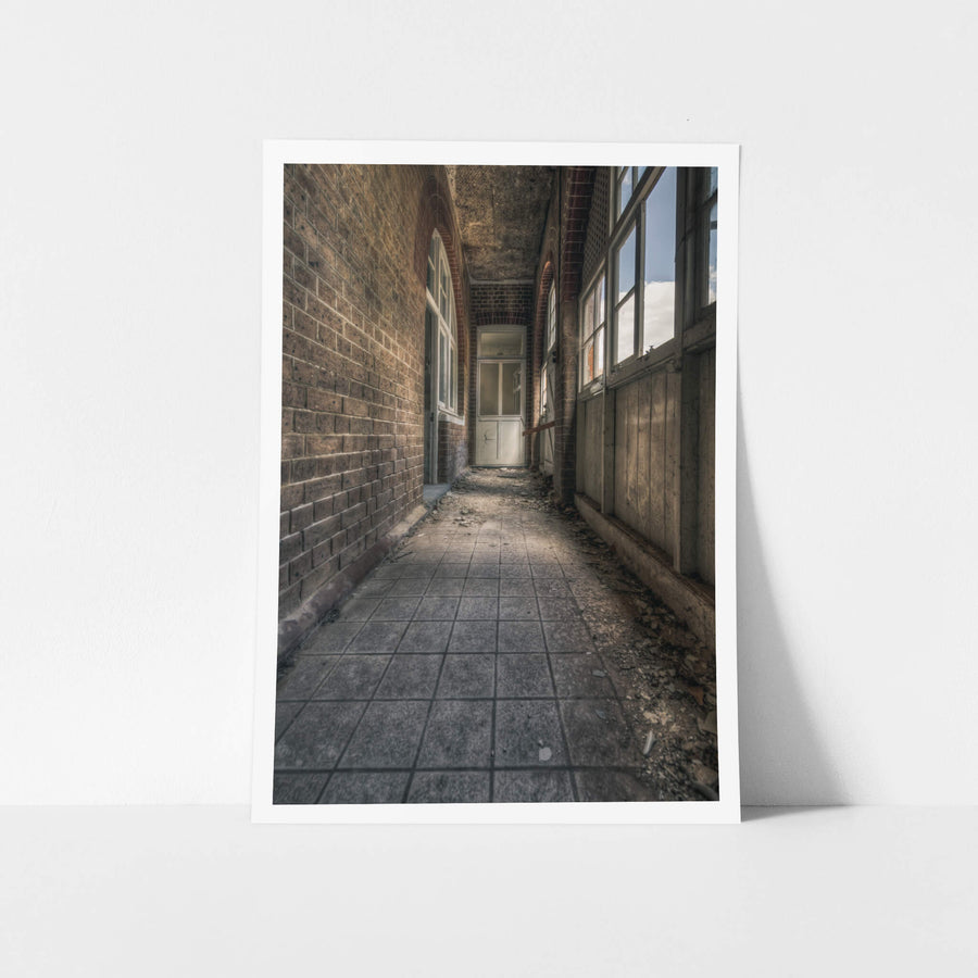 In Between at The Asylum, a narrow corridor runs between a brick wall and a timber-panelled enclosure.