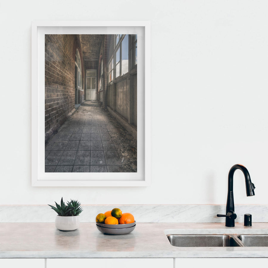 In Between at The Asylum, a narrow corridor runs between a brick wall and a timber-panelled enclosure.