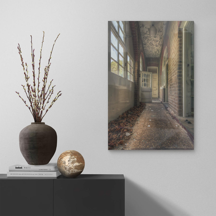 Pebblecrete Pavers at The Asylum, a narrow corridor runs between red brick columns and a rendered half-wall.
