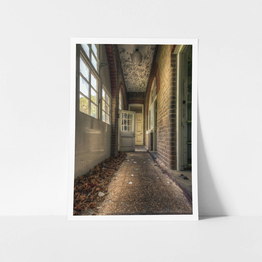 Pebblecrete Pavers at The Asylum, a narrow corridor runs between red brick columns and a rendered half-wall.