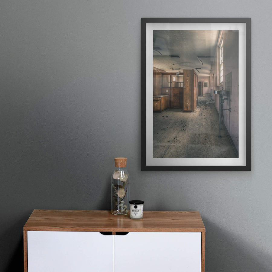 Slipping Away at The Asylum, a stainless steel basin hangs from exposed plumbing on the corridor wall.