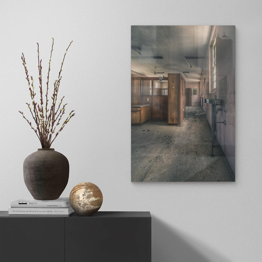 Slipping Away at The Asylum, a stainless steel basin hangs from exposed plumbing on the corridor wall.