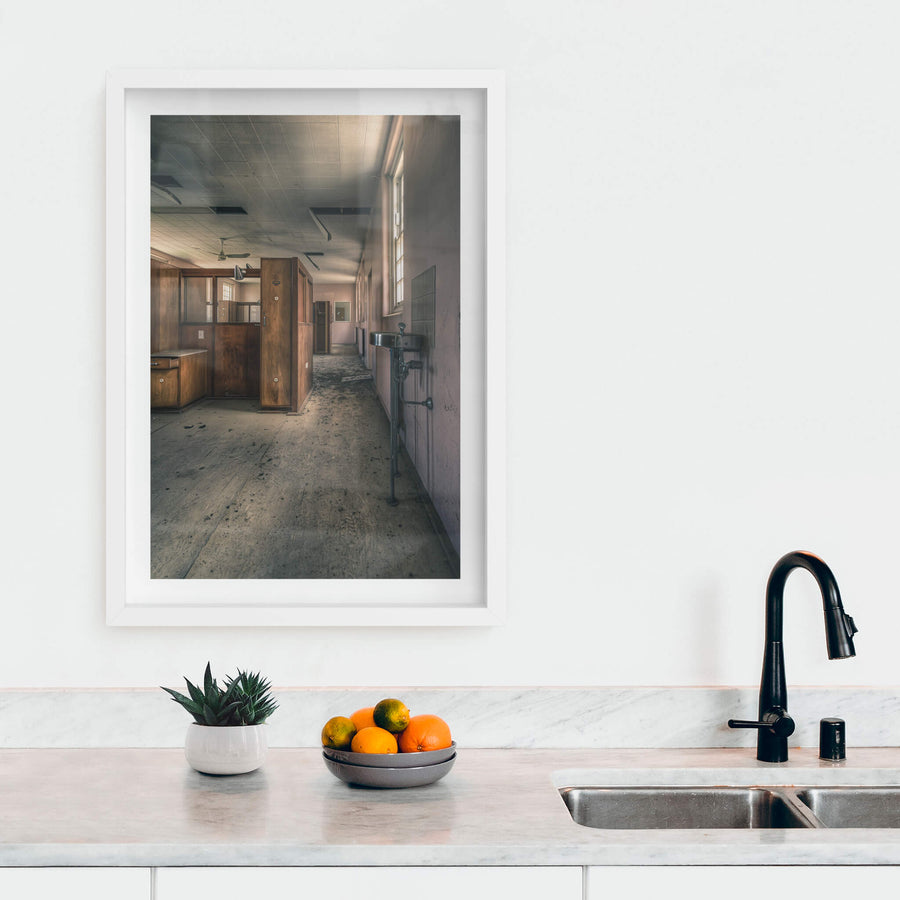 Slipping Away at The Asylum, a stainless steel basin hangs from exposed plumbing on the corridor wall.