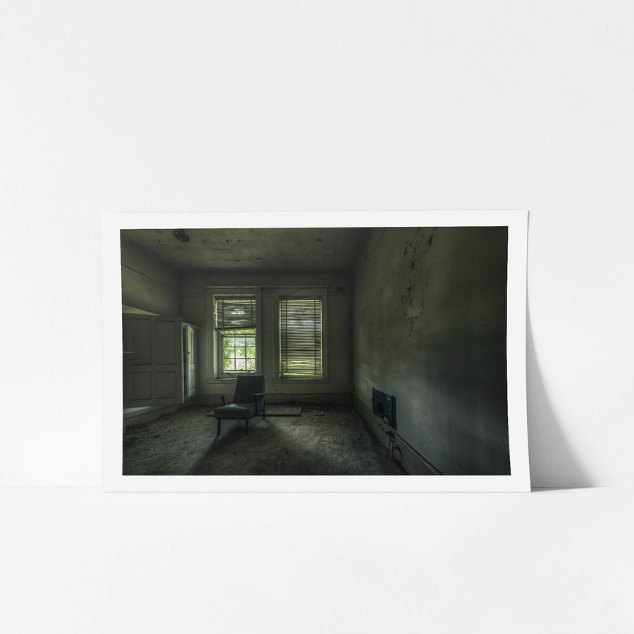 Slots of Light at The Asylum, a single vinyl chair sits near two windows in an otherwise empty room.