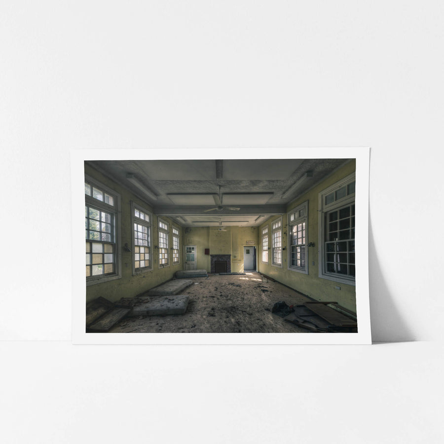 Spare Beds at The Asylum, a large common room with pale yellow walls and white-trimmed windows on three sides.