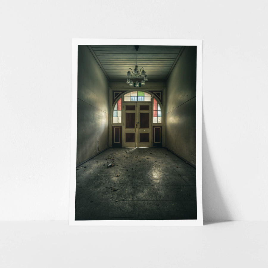 The Grand Entrance at The Asylum, a narrow entrance hall opens toward double timber doors set within an arched frame.
