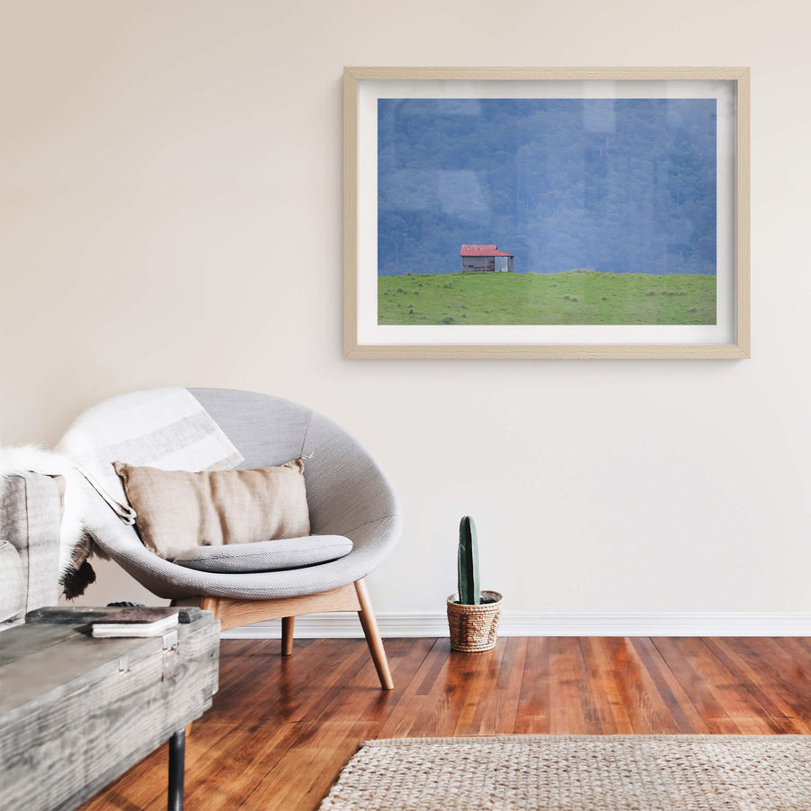 Brown Mountain Backdrop at The Dairy, a single timber and corrugated iron hut sits on a green ridge, small against.