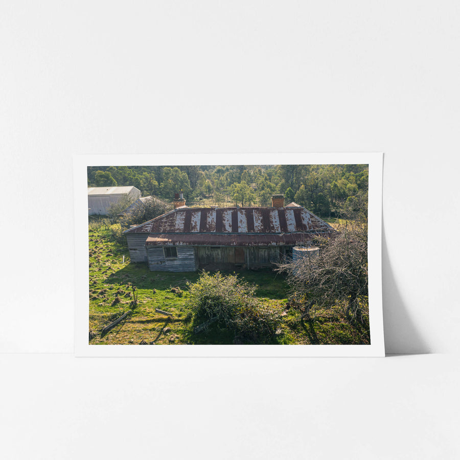 Frontside Elevated at The Post Office, a weatherboard homestead sits low against green pasture, seen from above.