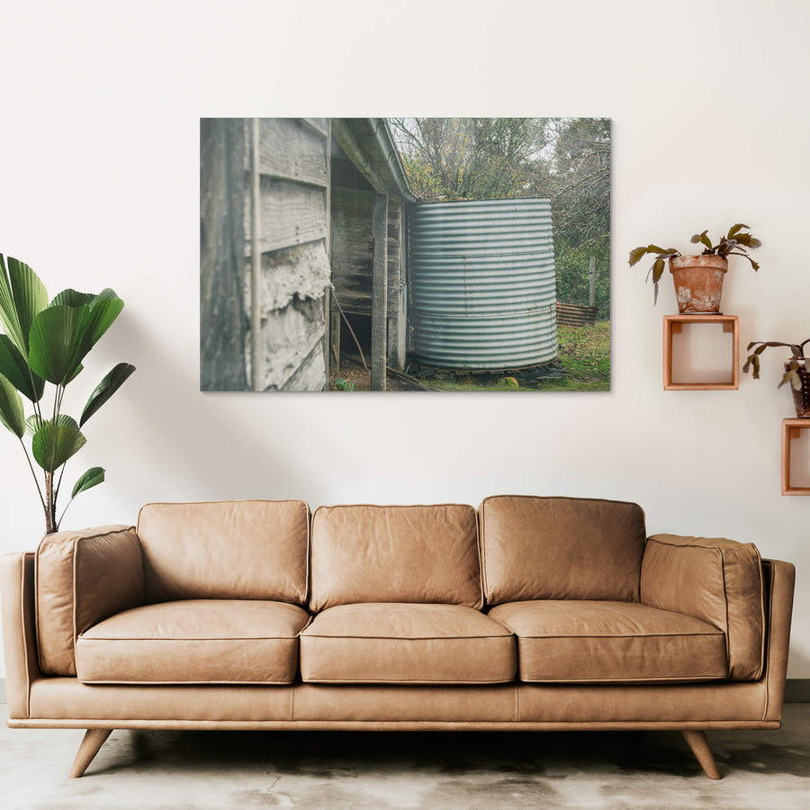 Water Tank at The Post Office, a corrugated steel water tank sits tight against the back corner of a timber outbuilding.