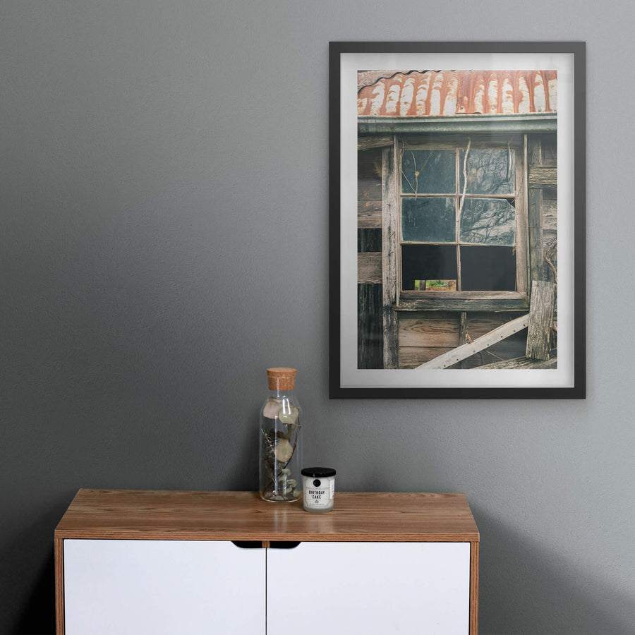 Window Panes at The Post Office, a six-pane timber window set into weatherboard cladding, grey and split with age.