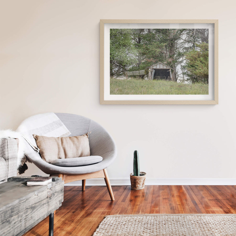 Hilltop Shed at The Woolshed, a small timber shed sits low on a grassed hilltop, its gable face open to the paddock.