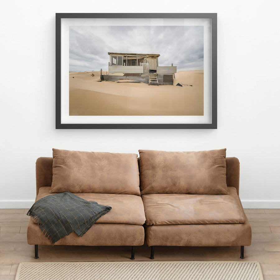 Eleven at Tin City, clean lines in a sandy foreground before a weathered Tin City shack.