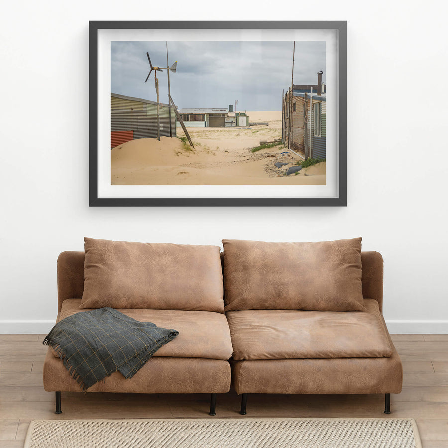 Facing South at Tin City, sand drifts between corrugated iron shacks, banking up against walls and burying the base.