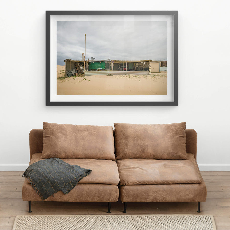 Nine at Tin City, corrugated iron and shade cloth hold together a low sprawl of shack against the dunes.