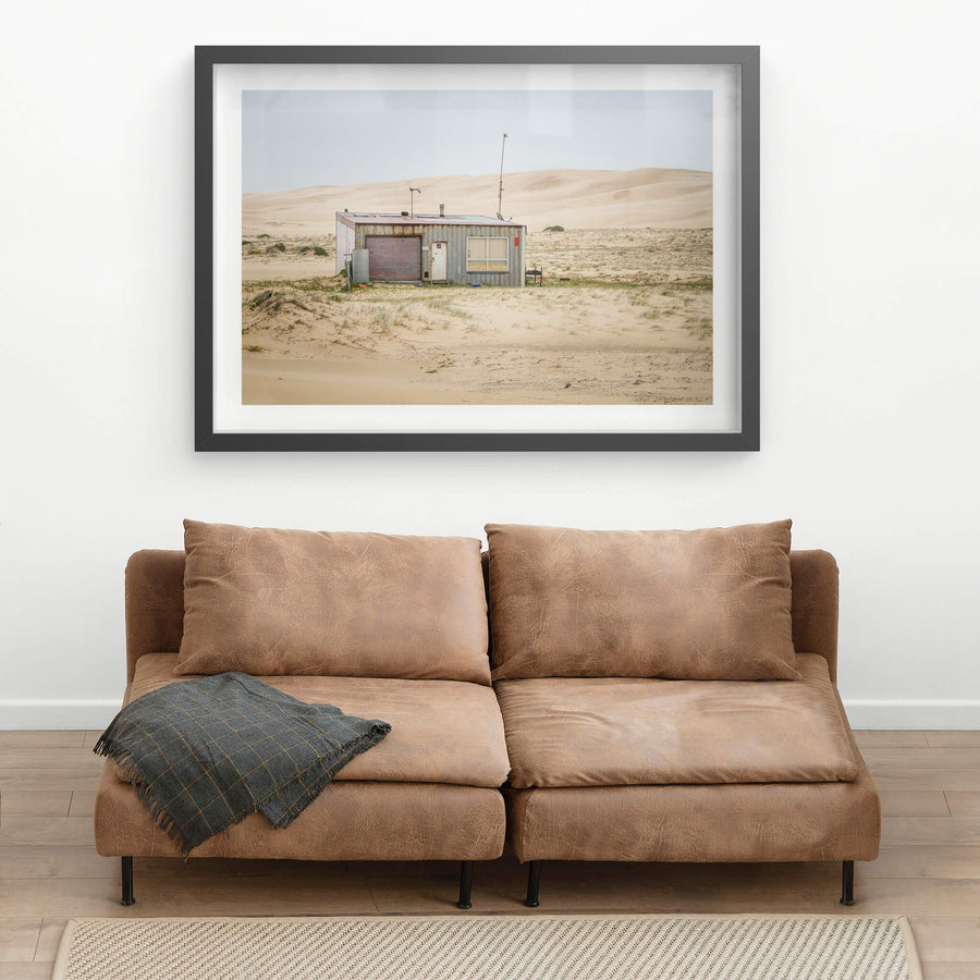 Seven Seven South West at Tin City, shack number seven sits alone against a wall of sand dunes that rises behind it like.