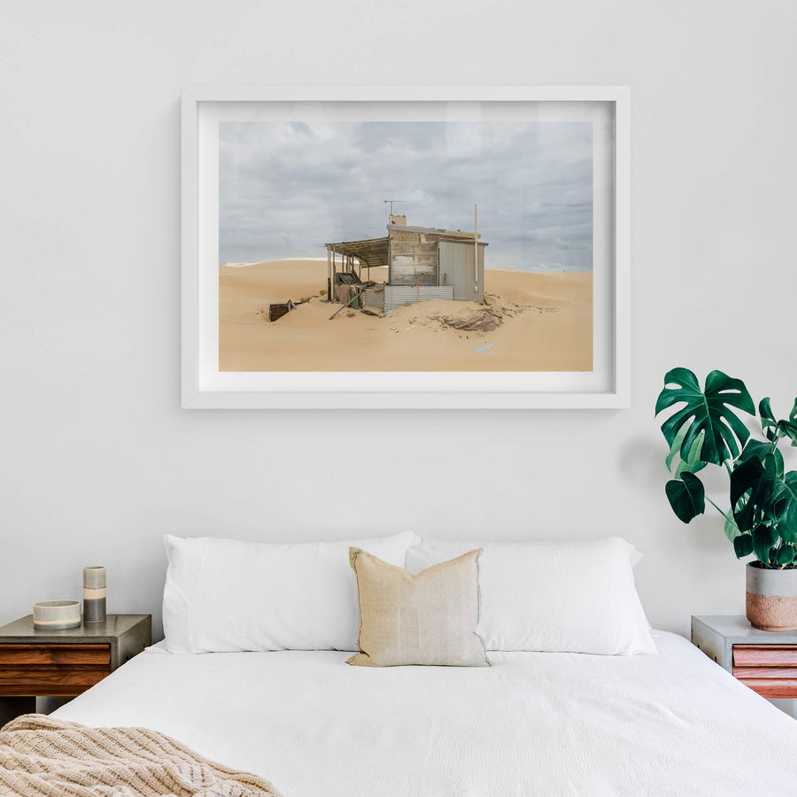 The Porch at Tin City, a corrugated iron shack sits half-swallowed by sand.