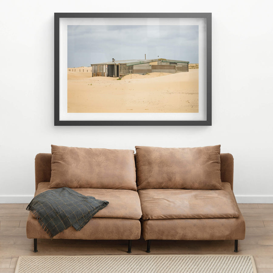 The Workshop at Tin City, a low corrugated iron structure sits half-swallowed by sand dunes at Tin City.