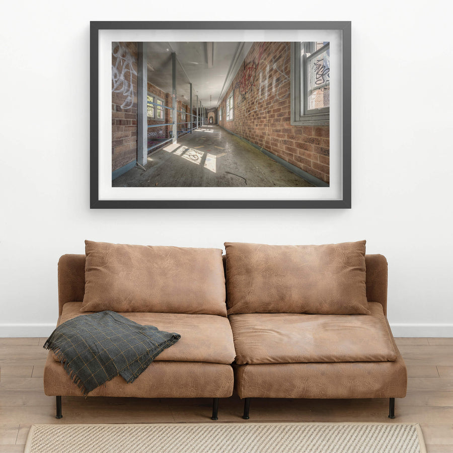 Switchback at Waterfall Sanatorium, a long corridor stretches deep into the building, flanked by brown brick walls thick.