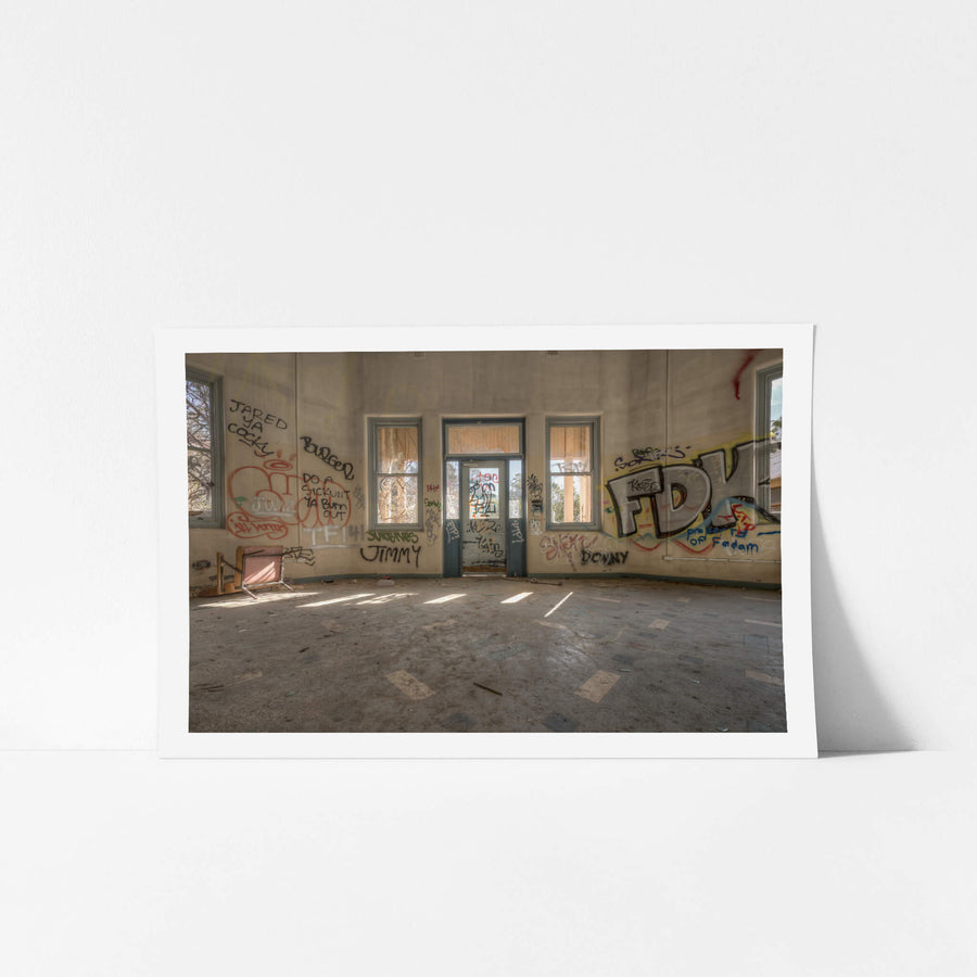 The Way Out at Waterfall Sanatorium, sunlight falls in pale strips across a bare concrete floor.