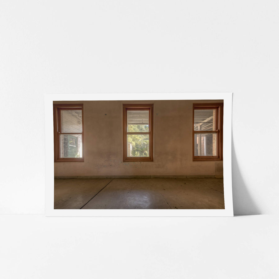 Three Windows at Waterfall Sanatorium, three timber-framed windows sit evenly spaced across a rendered wall.