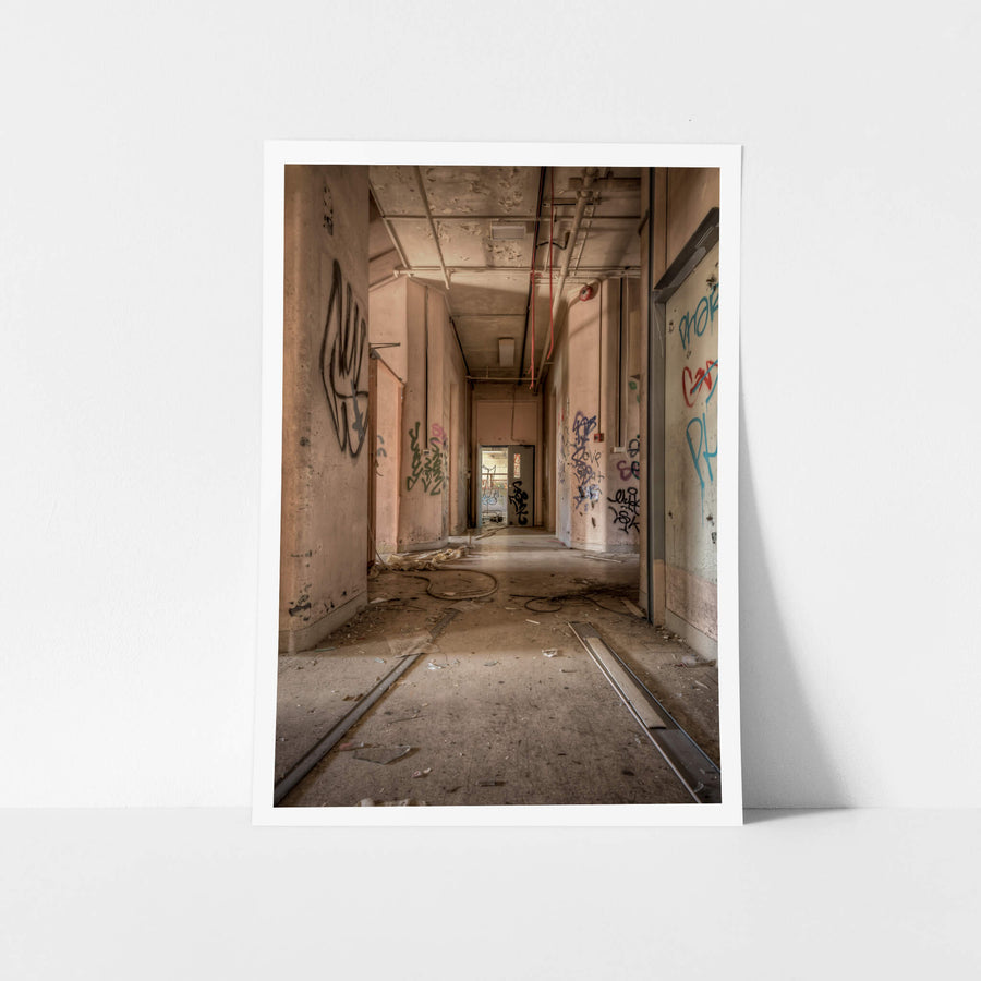 Ward Hall at Waterfall Sanatorium, a corridor stretches toward a single doorway where daylight enters.
