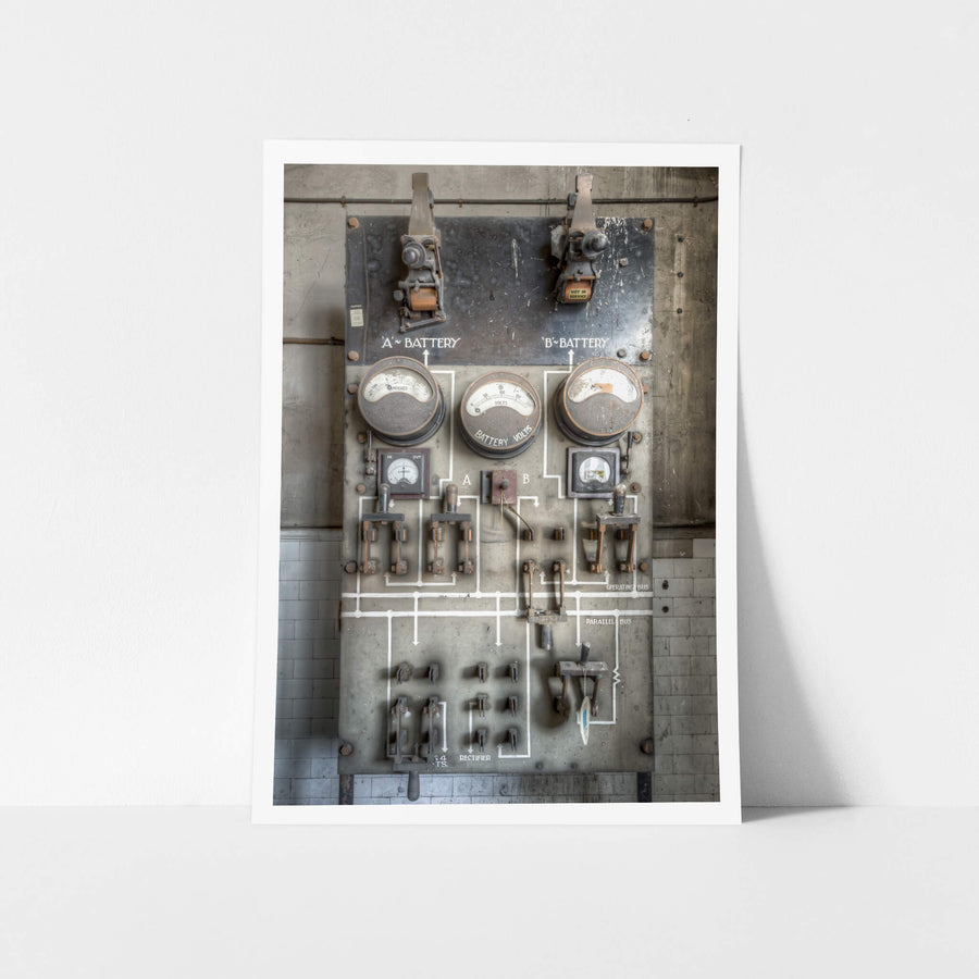 Battery Charger at White Bay Power Station, a battery charging board mounted on a grey steel panel against white-tiled walls.