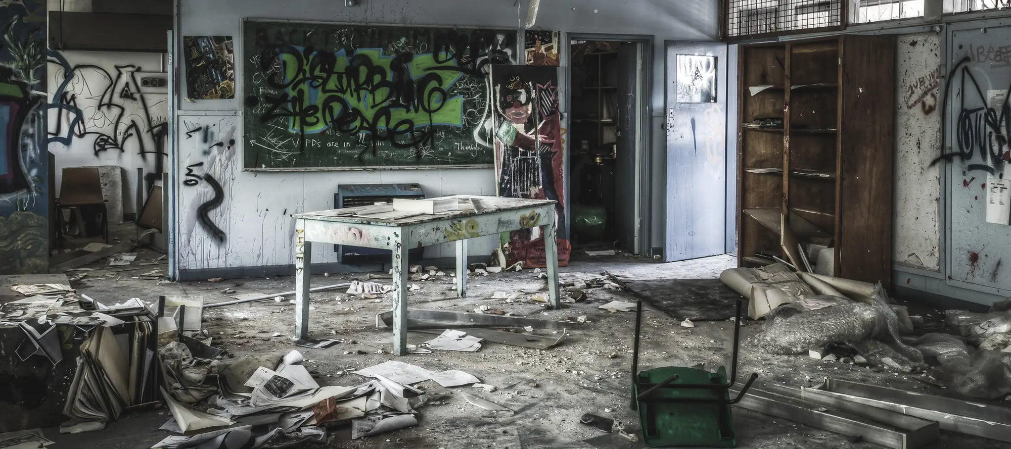 Abandoned classroom at Macquarie Boys Technology High, covered in graffiti and strewn with debris, showcasing the school’s state of decay.