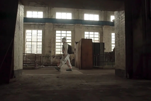 Brett Patman exploring the abandoned White Bay Power Station, wearing protective gear inside the decayed industrial space with large windows in the background.