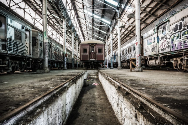 Looking down a service pit between rail roads at the Eveleigh Paint Shop, the sawtoothed roof visible above
