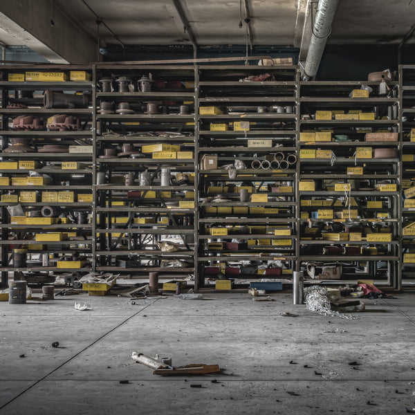 Workshop storage shelves at Wangi Power Station, stacked with yellow industrial tins and spare parts.