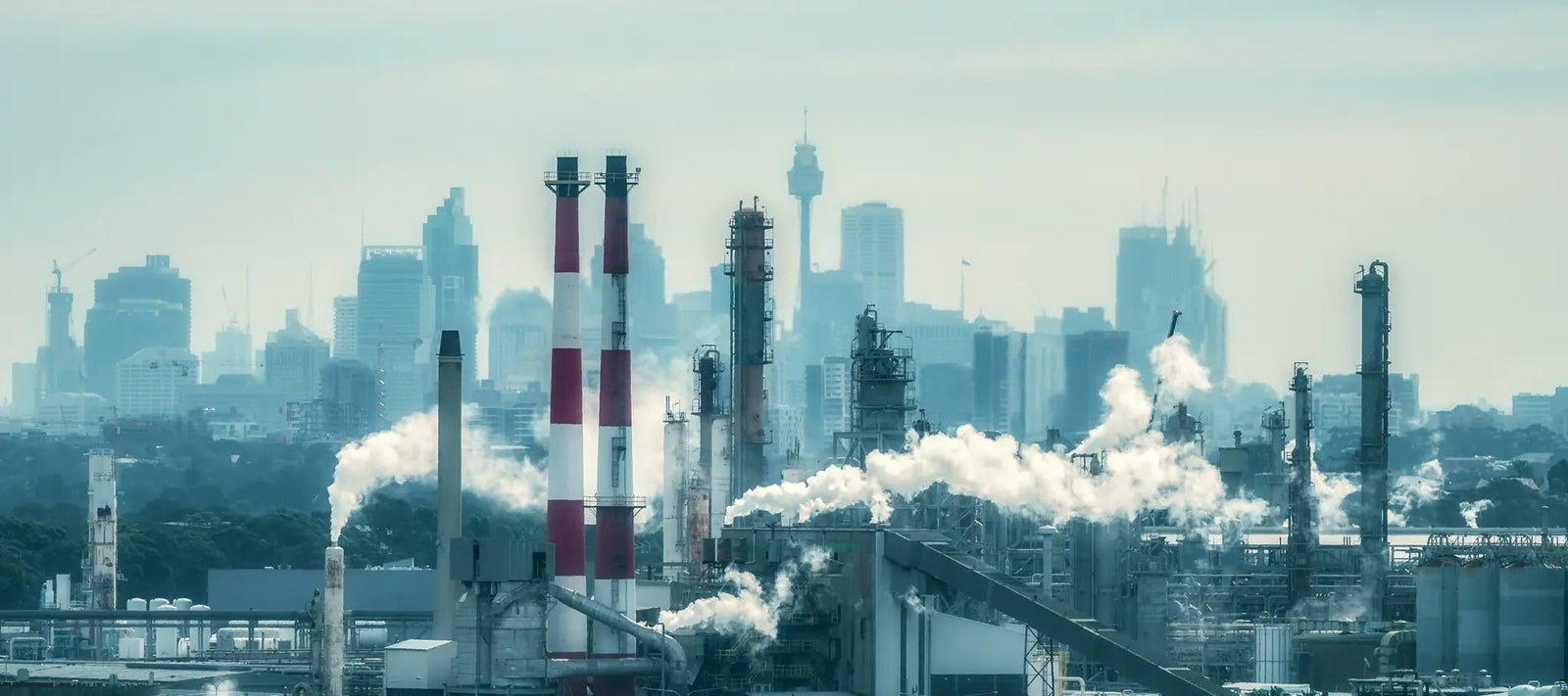 A remote scene featuring corrugated metal structures amidst rolling sand dunes, blending human-made architecture with the stark beauty of the natural desert landscape.