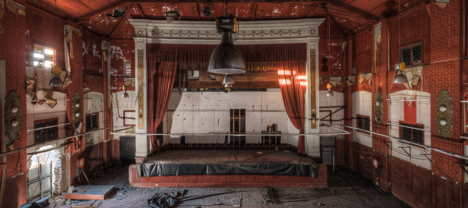 Interior of the Marina Picture Palace in Rosebery, showcasing its vintage theater stage with peeling wallpaper and industrial lighting.