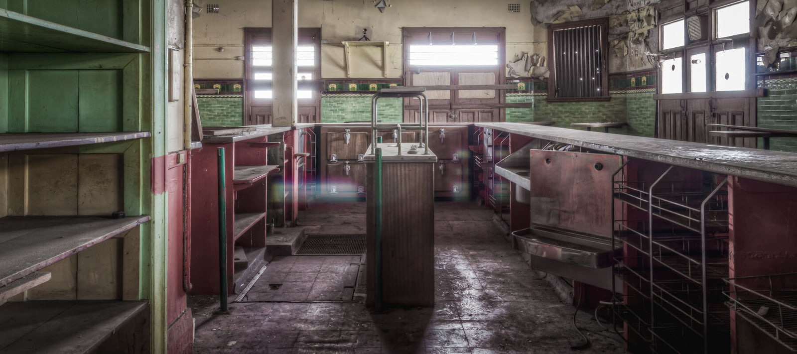 Interior view of the vintage bar at Terminus Hotel, showcasing worn shelves, a metal counter, and rustic, historic decor.