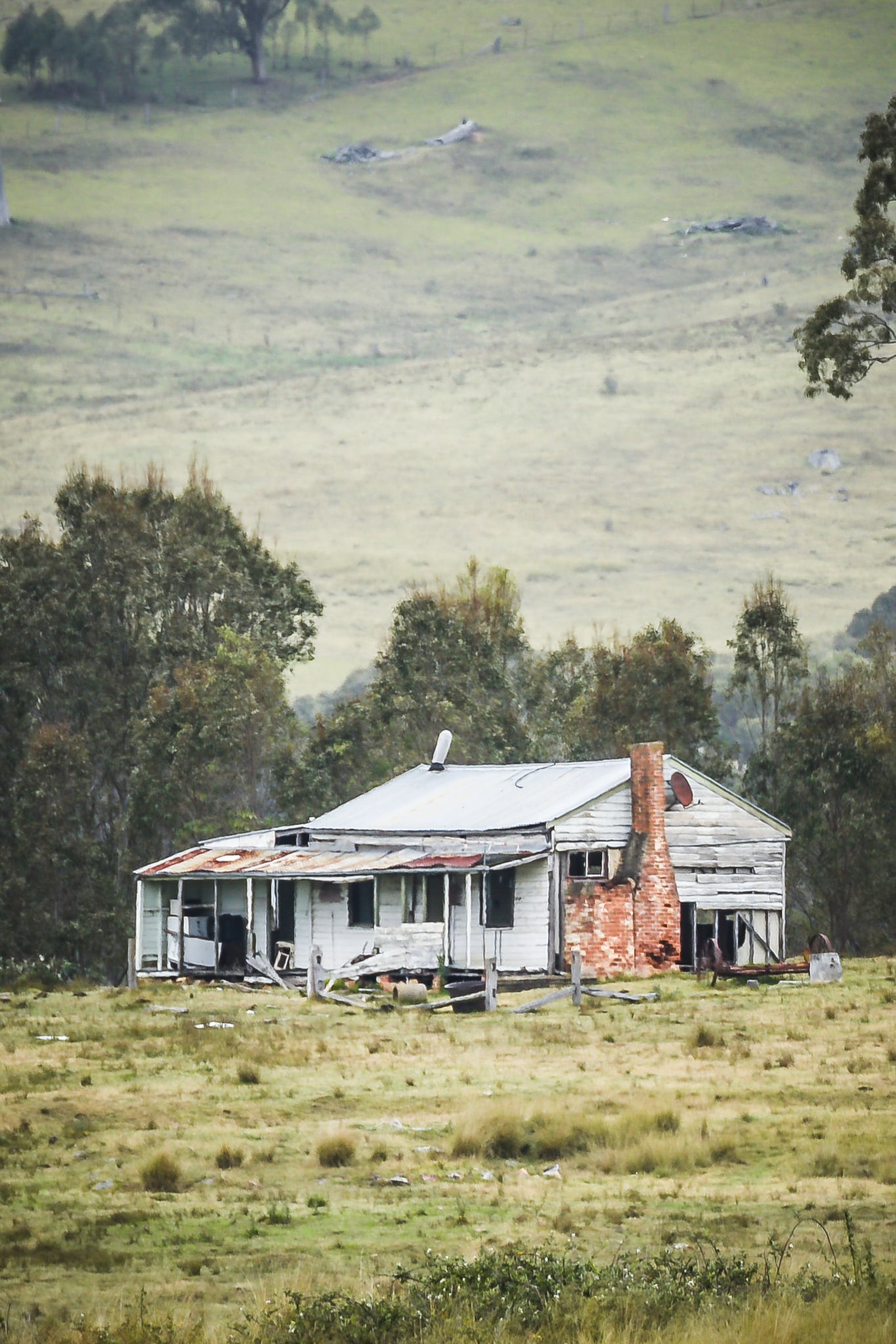 Home In The Valley at A Place to Call Home, a weatherboard farmhouse sits alone in open grazing country.