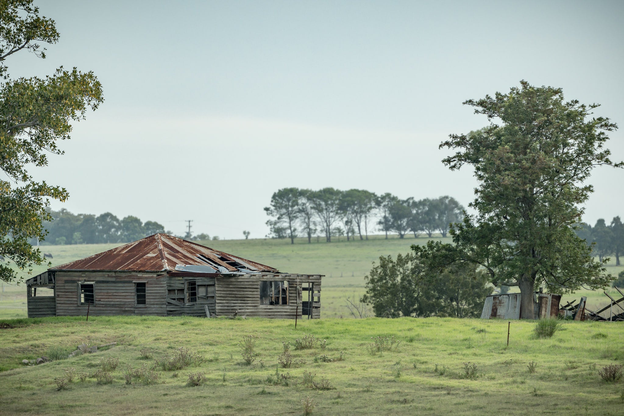 Hunter Homestead at A Place to Call Home, a weatherboard farmhouse sits low in open paddock, its hip roof a patchwork.