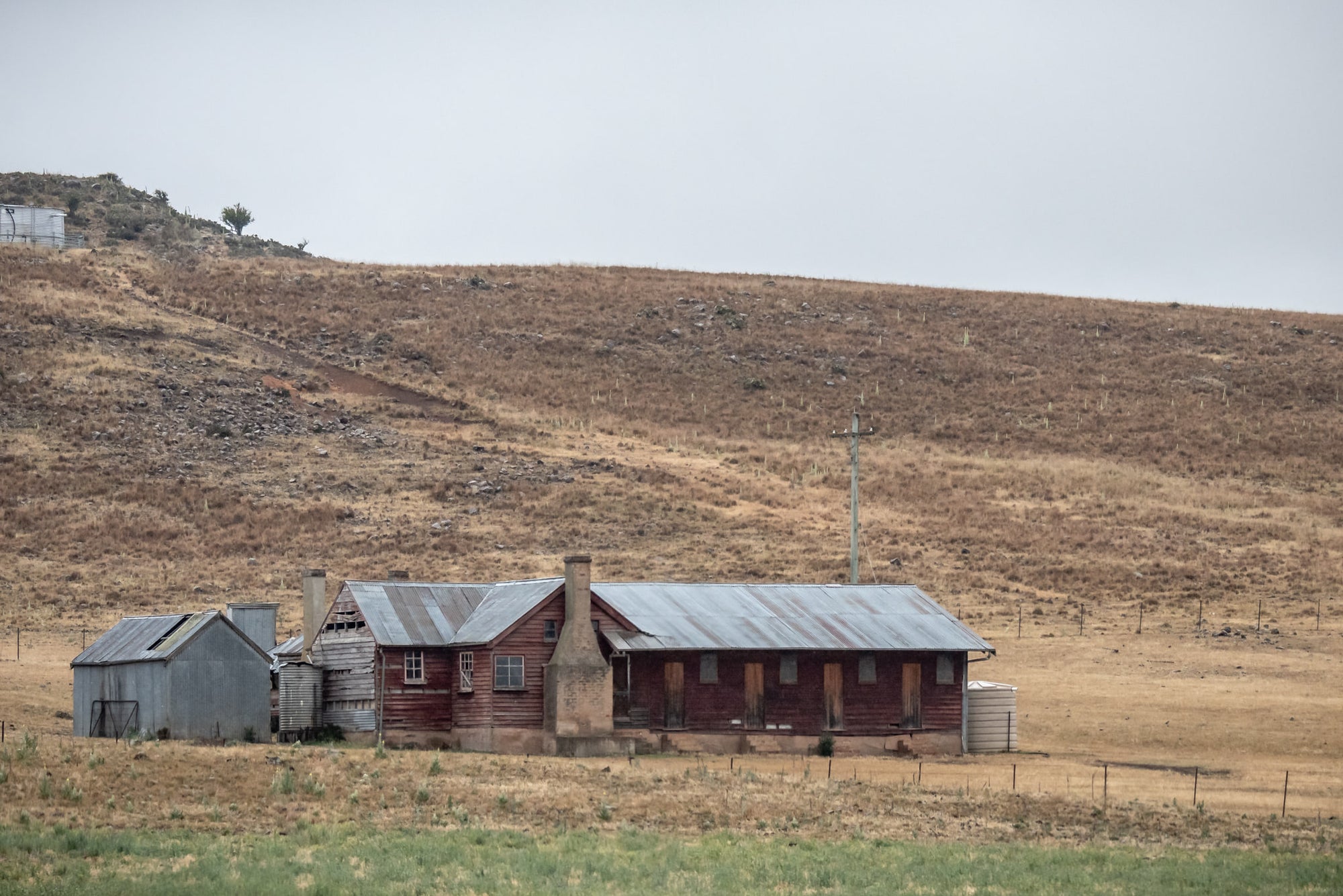 Shearers Quarters at A Place to Call Home, a low timber homestead sits against a bare hillside in rural New South Wales.