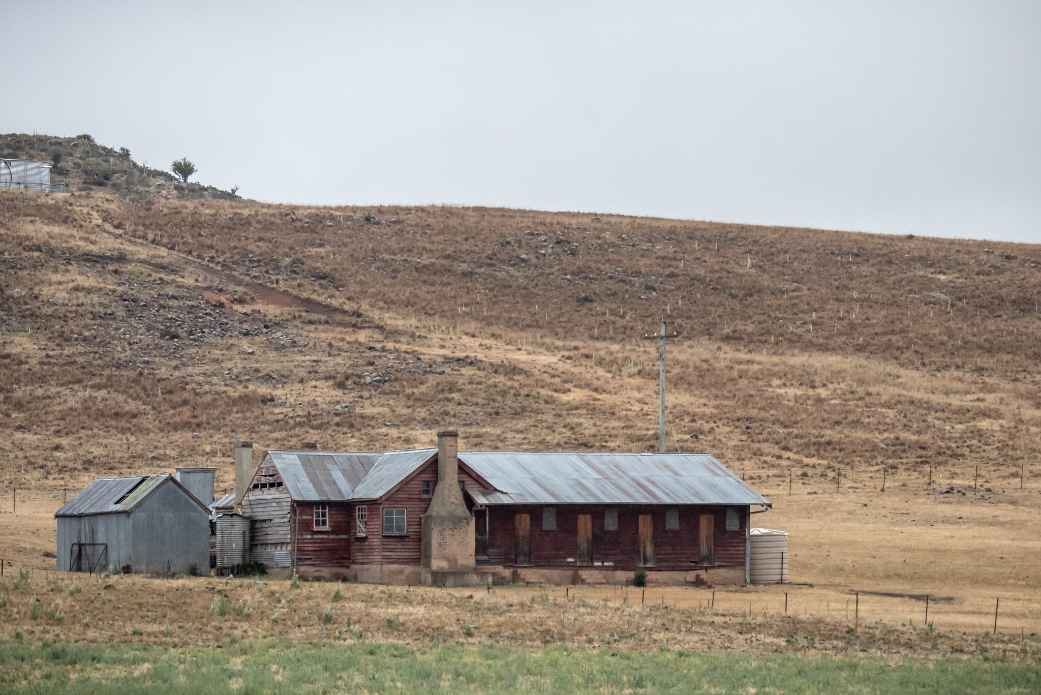 Shearers Quarters at A Place to Call Home, a low timber homestead sits against a bare hillside in rural New South Wales.