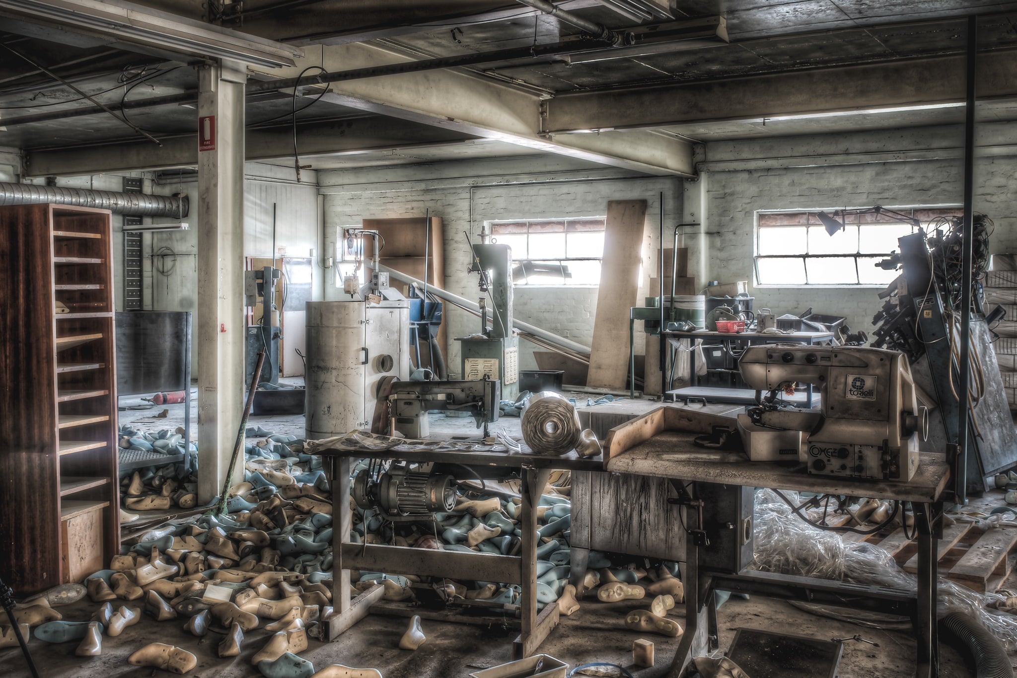 Sewing Desk at Abandoned Shoe Factory, a couple of sewing machines used for hand stitching shoes.
