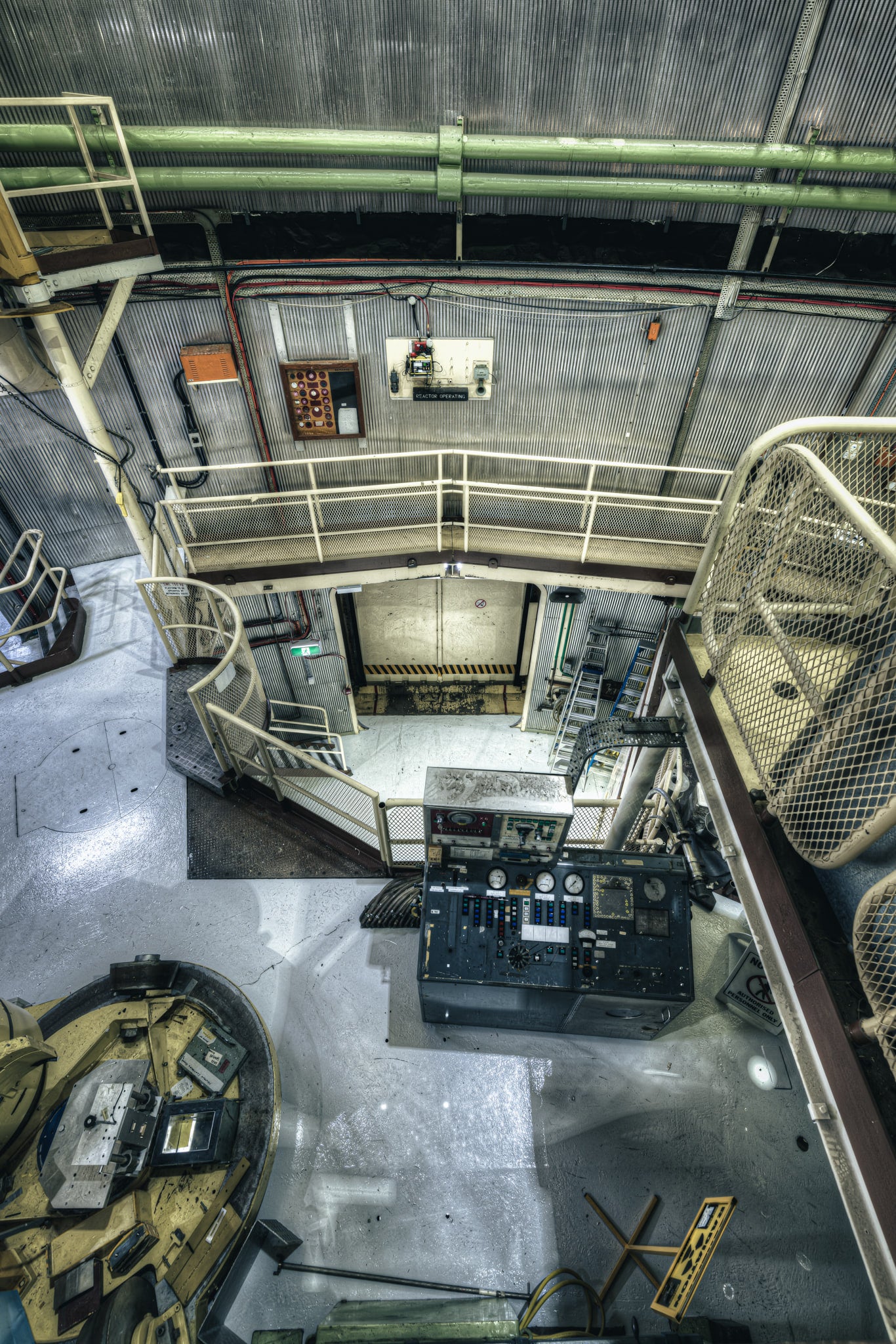 Mezzanine to Vehicle Airlock at ANSTO HIFAR, green coolant pipes run beneath a corrugated steel ceiling.