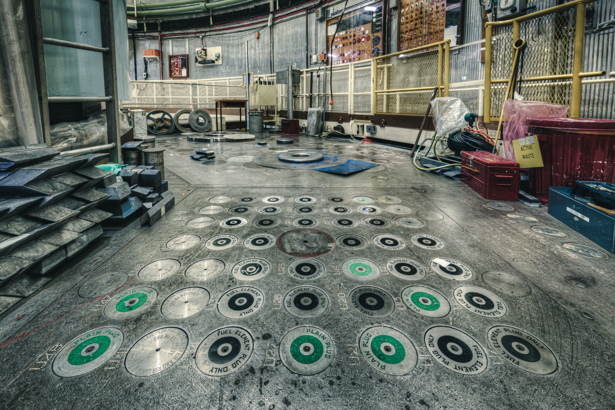 No 1 Storage Block at ANSTO HIFAR, dozens of circular plugs are set into the reactor's charge face, each stamped "FUEL.